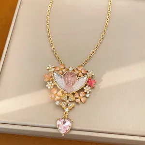 Vista dettagliata della collana angelo vintage con cuore di cristallo rosa e pendente.