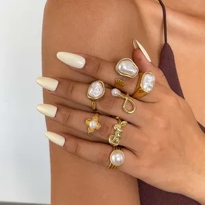 Close-up of 7-piece vintage pearl ring set with irregular geometric and flower designs