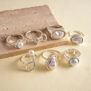 Detailed view of a seven-piece vintage silver ring set with pearls on a stone background