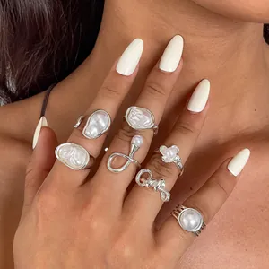 Detailed macro view of seven-piece retro irregular geometric pearl flower ring set for women