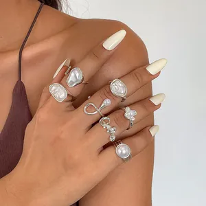 7-piece set of silver retro rings with pearls and irregular geometric designs on woman's hand