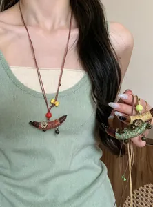 Handgemaakte etnische ketting met kleurrijke touw-omwikkelde houten maan-hanger