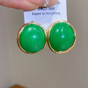 Vintage green oval resin stud earrings with gold metal frame detailed close-up view.