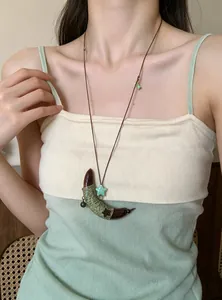 Close-up van een prachtige handgemaakte etnische houten maan-hanger ketting op een model
