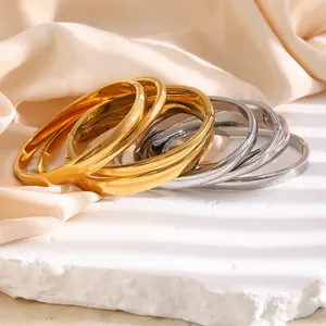 Gestapelte minimalistische Titanstahl-Armreifen in Gold und Silber