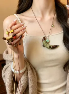 Detail van een etnische ketting met houten halve maan hanger omwikkeld met gekleurd touw
