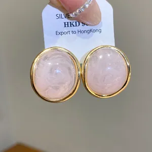 Detailed macro view of vintage oval pink resin stud earrings with gold-tone borders