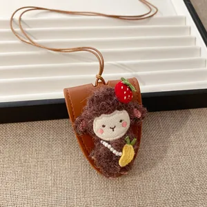 Primo piano di un ciondolo a forma di pecora di peluche con dettagli fragola e ananas
