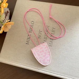 Détail d'un collier porte-lunettes élégant avec imprimé léopard rose sur livre