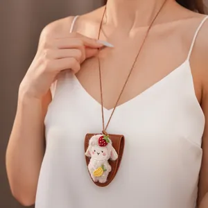 Dettaglio collana in pelle con ciondolo a forma di agnello in feltro e portaocchiali.