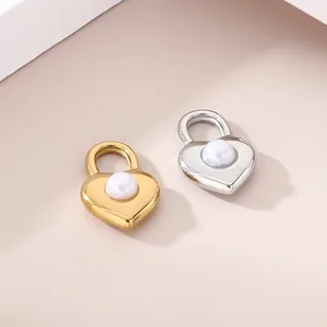 Pendenti a forma di cuore con perla intarsiata in finiture oro e argento.