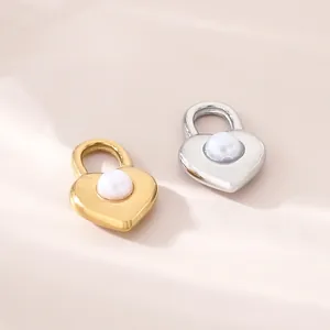 Primo piano di ciondoli a lucchetto a cuore in acciaio inossidabile con perle in oro e argento