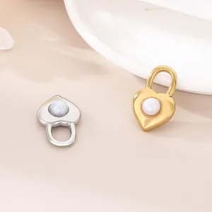 Vista dettagliata di eleganti ciondoli a lucchetto a cuore in oro e argento con perle