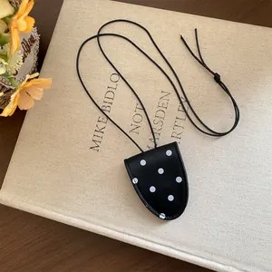 Détail d'un pendentif de collier porte-lunettes vintage en cuir à pois élégant