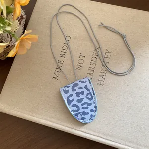 Gros plan d'un collier porte-lunettes vintage bleu à imprimé léopard avec cordon gris