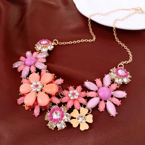 Vue détaillée d'un collier plastron fleuri avec pétales en résine et strass brillants.
