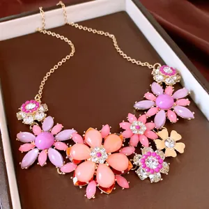 Gros plan macro d'un collier avec des pendentifs de fleurs en strass colorés et vifs