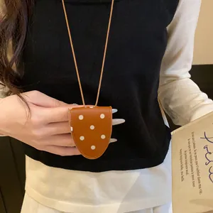 Gros plan d'un clip à lunettes vintage à pois porté comme un collier élégant.