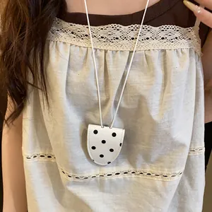 Vue détaillée d'un collier pince à lunettes à pois vintage porté sur un haut dentelle