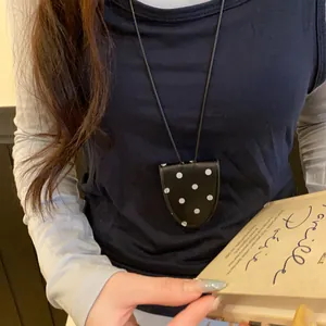 Gros plan d'un collier porte-lunettes rétro français noir à pois blancs élégant