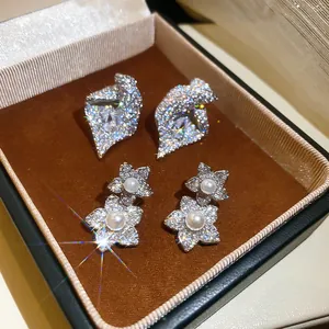 Gros plan de boucles d'oreilles fleurs en zircon élégantes avec perles en boîte