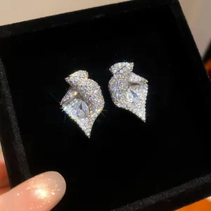 Gros plan de boucles d'oreilles fleur en zircon étincelant dans un écrin noir