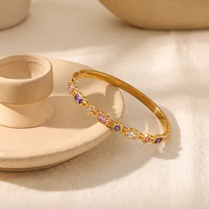 Detailaufnahme eines goldenen Edelstahlarmbands besetzt mit bunten quadratischen Zirkonia Steinen