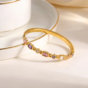 Detailansicht eines luxuriösen goldenen Edelstahl-Armreifs mit bunten Zirkon-Einlagen