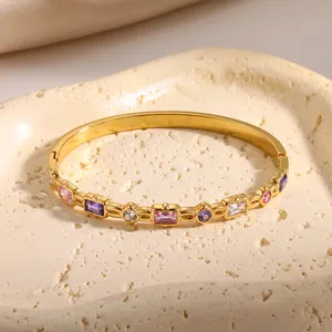 Nahaufnahme eines goldenen Armreifs aus Edelstahl mit bunten rechteckigen Zirkonia
