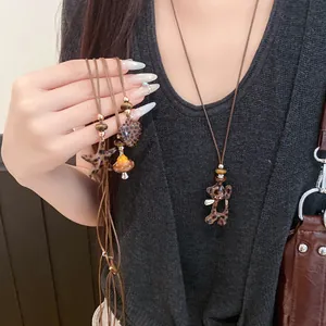 Détail de colliers vintage avec perles léopard et pendentifs en forme de cœur et d'ours