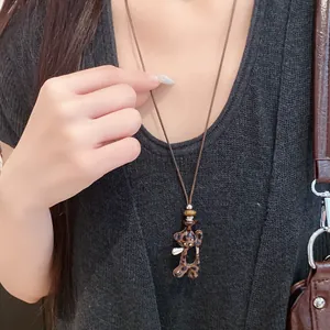Détail du collier vintage avec pendentif cœur léopard et cordon en cuir brun
