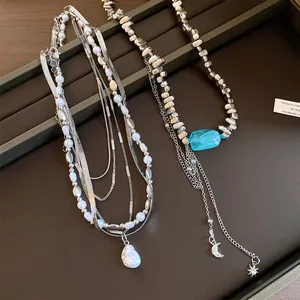 Nahaufnahme der unregelmäßigen mehrlagigen Perlenkette mit Stern-Mond-Anhängern und Quasten