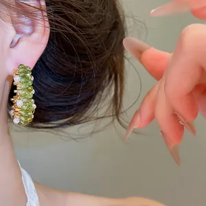 Gedetailleerde close-up van elegante groene kristallen kralen oorbellen gedragen aan het oor