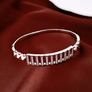 Vista dettagliata di un lussuoso bracciale rigido traforato rettangolare con zirconi