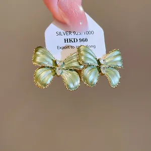 Gedetailleerd overzicht van de groene vlinder oorbellen met fonkelende kristallen