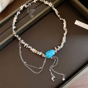 Detailansicht der unregelmäßigen Silberperlen und des blauen Steins mit Stern- und Mondquasten.