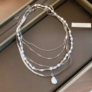 Detailansicht einer mehrlagigen Silberkette mit Barockperlen auf einem Displaytablett.