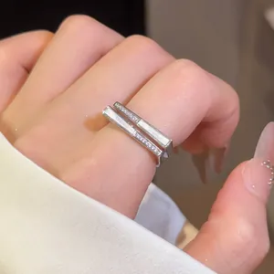 Close-up of elegant silver square open rings with zircon stones and white plate inlay
