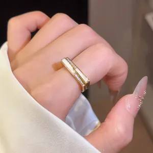 Detail shot of a minimalist gold square open ring with white shell inlay and zircon