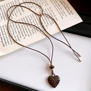 Détail du pendentif cœur rétro à motif léopard sur collier en cordon ajustable