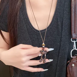 Vue détaillée d'un collier vintage avec pendentif ours léopard sur un cordon en cuir réglable.