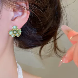 Detailweergave van groen geëmailleerde bloemoorbellen met centrale zirkoon op het model