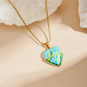 Gros plan détaillé du collier à pendentif en cœur avec peinture florale à l'huile