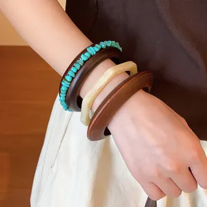 Close-up of Maillard style vintage resin and wood bracelet set on a woman's wrist.