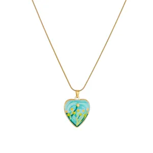Vue détaillée du pendentif cœur en émail avec motif floral peint sur chaîne dorée.