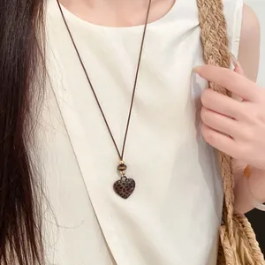 Vue détaillée d'un collier vintage avec pendentif cœur léopard sur un cordon réglable.