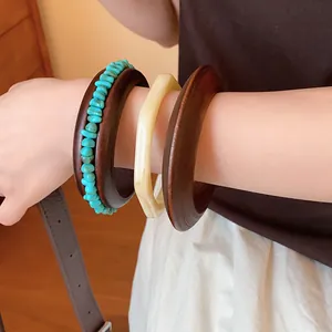 Retro Maillard style resin bangle set worn on wrist with turquoise beads and geometric detail