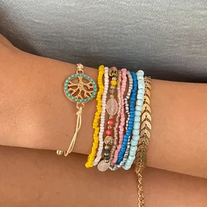 Gros plan d'un ensemble de 10 bracelets bohèmes avec des perles colorées et feuilles