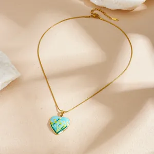Vue détaillée du pendentif cœur à fleurs peint à la main sur ce beau collier doré