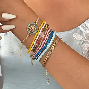 Gros plan sur un ensemble de 10 bracelets bohèmes avec breloques arbre de vie et feuilles
